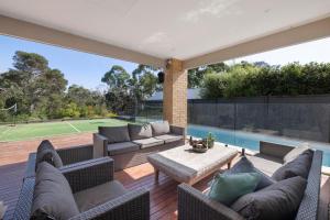 a patio with a couch and a table and a pool at Corymbia Mount Martha in Mount Martha