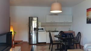 a kitchen with a refrigerator and a table with chairs at Apartments by the sea Kaprije - 20012 in Kaprije