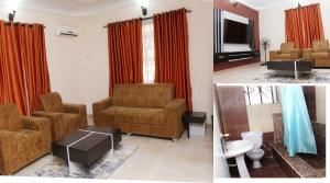 a living room with two chairs and a tv at Laribond's Place in Lagos
