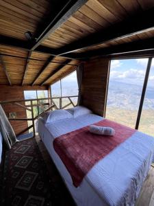 una camera con un letto in una stanza con finestre di Entre Cumbres - Cabaña con vista a la cordillera 