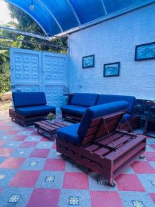 un patio con 2 sillas azules y un sofá en Casa con piscina, en El Colegio