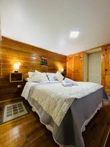 een slaapkamer met een groot bed en houten wanden bij Apartamento Coyhaique in Coihaique