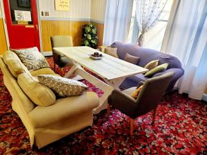 ein Wohnzimmer mit einem Tisch und Stühlen in der Unterkunft Monte Villa Hotel in Monte Vista