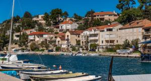 een groep boten aangemeerd in een haven met huizen bij Amare Apartments in Bobovišća