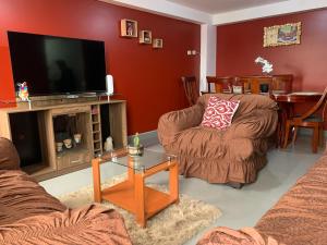 a living room with two chairs and a flat screen tv at El Viejo Roble in Cusco