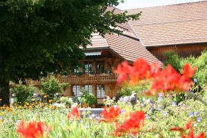 una casa con un jardín de flores delante de ella en Restaurant Hotel Rüttihubelbad, en Walkringen