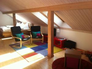 Zimmer im Dachgeschoss mit 2 Stühlen und einem Bett in der Unterkunft Restaurant Hotel Rüttihubelbad in Walkringen