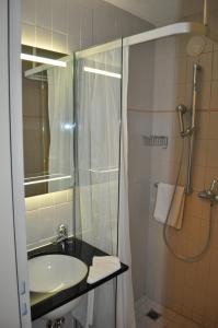a bathroom with a sink and a shower at Restaurant Hotel Rüttihubelbad in Walkringen