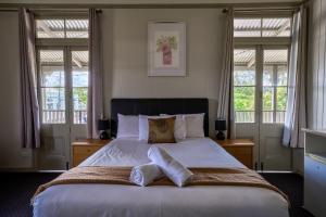a bedroom with a large bed with two windows at Yandina Hotel in Yandina