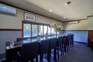 a long table in a room with chairs and flowers at Yandina Hotel in Yandina