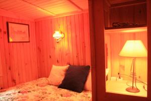 Saint Laurent NouanにあるRoulotte en Sologneのベッドルーム1室(ベッド1台、ランプ、ランプ付)