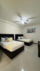 2 bedden in een kamer met een plafondventilator bij Hotel Real Jaguar in Tuxtla Gutiérrez