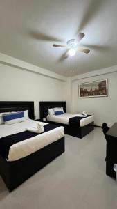 two beds in a room with a ceiling fan at Hotel Real Jaguar in Tuxtla Gutiérrez +7 photos