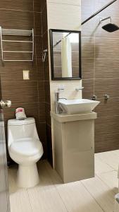 a bathroom with a toilet and a sink and a mirror at Hotel Real Jaguar in Tuxtla Gutiérrez