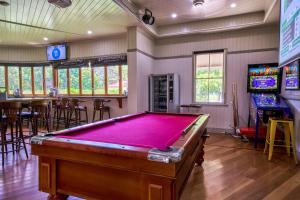 a pool table in a room with a video game at Yandina Hotel in Yandina