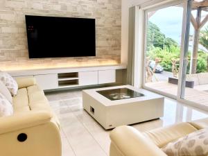 a living room with a tv on a wall at HOKULANI by the sea - Vacation STAY 68088v in Isumi
