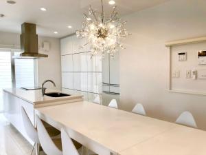 a kitchen with a white table and a chandelier at HOKULANI by the sea - Vacation STAY 68088v in Isumi