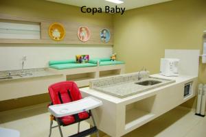 cocina con encimera con fregadero y silla roja en Apto no Veredas do Rio Quente, en Rio Quente 9 fotos más