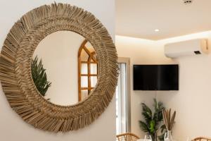 マリーニャ・グランデにあるMarinha Grande Apartamentos N2 ZENのリビングルームに掛けられた大きな籐鏡