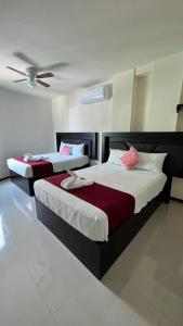 2 bedden in een slaapkamer met een plafond bij Hotel Real Jaguar in Tuxtla Gutiérrez