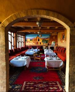 a dining room with tables and red couches at kasbah amlal in Tinerhir