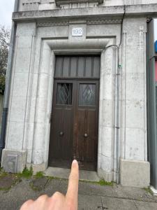 uma pessoa a apontar para um edifício com uma porta em L'Atmosphère - Campus / Université em Rhut