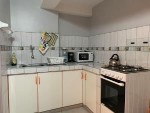 a kitchen with white cabinets and a stove top oven at El Viejo Roble in Cusco +35 photos