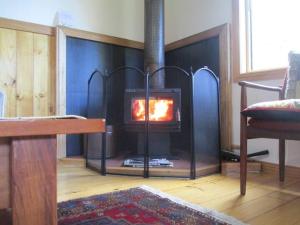 a fireplace in a living room with a fire in it at Post House Cottage in Fentonbury