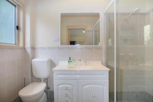 a bathroom with a toilet and a sink and a shower at Blue Paradise on Coorilla in Hawks Nest +19 photos