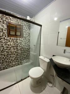a bathroom with a toilet and a sink at Ibitisuítes chalé in Lima Duarte