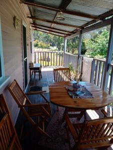a patio with a wooden table and chairs on a porch at Post House Cottage in Fentonbury