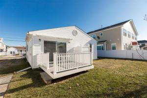 a small white building with a porch in a yard at 204 E Syracuse Ave in Wildwood Crest