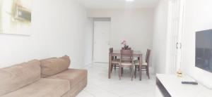 uma sala de estar com um sofá e uma mesa em Incrível apartamento Balneário Camboriú em Balneário Camboriú