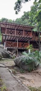 ein großes Holzhaus am Straßenrand in der Unterkunft Cabaña Altos de San Carlos in Santa Marta