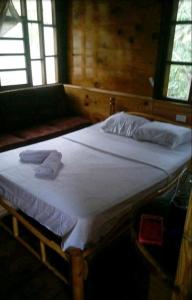 a bed in a room with two towels on it at Cabaña Altos de San Carlos in Santa Marta