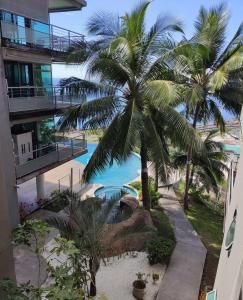 a view of the pool from the balcony of a building at Résidence Standing 1ch / Piscine / Salle de Sport in Faaa