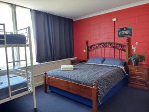 アデレードにあるポート アデレード バックパッカーズの赤い壁のベッドルーム1室