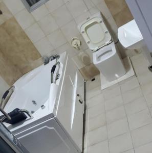 ein kleines Bad mit einer Badewanne und einem WC in der Unterkunft Laribond's Place in Lagos