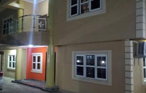 ein Gebäude mit einer roten Tür und einigen Fenstern in der Unterkunft Laribond's Place in Lagos