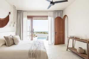 una camera da letto con un letto e una grande finestra di Villa Zyloh Sunset - New, Luxury, Ocean View Villa, Bingin a Uluwatu Altre 19 foto