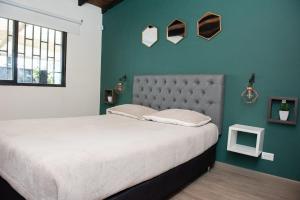Un dormitorio con una cama grande y una pared verde en El Cielo en la Vereda Barroblanco de Santa Elena, en Medellín