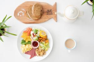 a white table with a plate of food and a cup of coffee at Deer House in Yung-an-ts'un