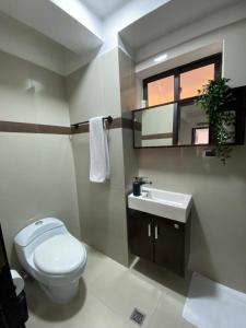 a bathroom with a toilet and a sink and a window at Elegante apartamento en Playa el Angel in Porlamar