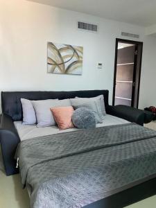 Una cama grande con varias almohadas encima. en Elegante apartamento en Playa el Angel en Porlamar