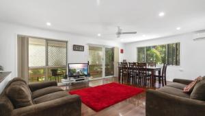 a living room with a couch and a tv and a table at Family Friendly House With Pool & Aircon in Woorim