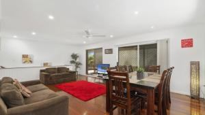 a living room with a table and a couch and a dining room at Family Friendly House With Pool & Aircon in Woorim