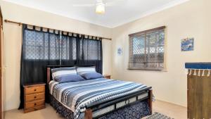 ein Schlafzimmer mit einem Bett und einem Fenster in der Unterkunft Cottage By The Surf Beach in Woorim