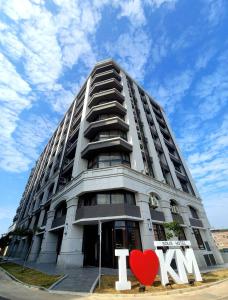 a tall building with a heart sign in front of it at 金金禮寓Solis hotel in Jinhu