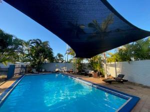 une grande piscine bleue dans une cour dans l'établissement Tasman Holiday Parks - Torquay Palms, à Hervey Bay