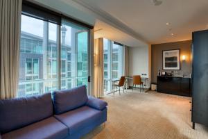 a living room with a couch and large windows at Marsden Viaduct in Auckland